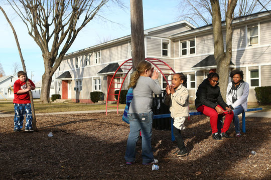 Center: Bella Kanable, 8, and Myaire Jackson, 5, play a hand clap game on one of the playgrounds at Garden Square Apartments on Saturday, February 27, 2016. (Kelly Lafferty Gerber | Kokomo Tribune)